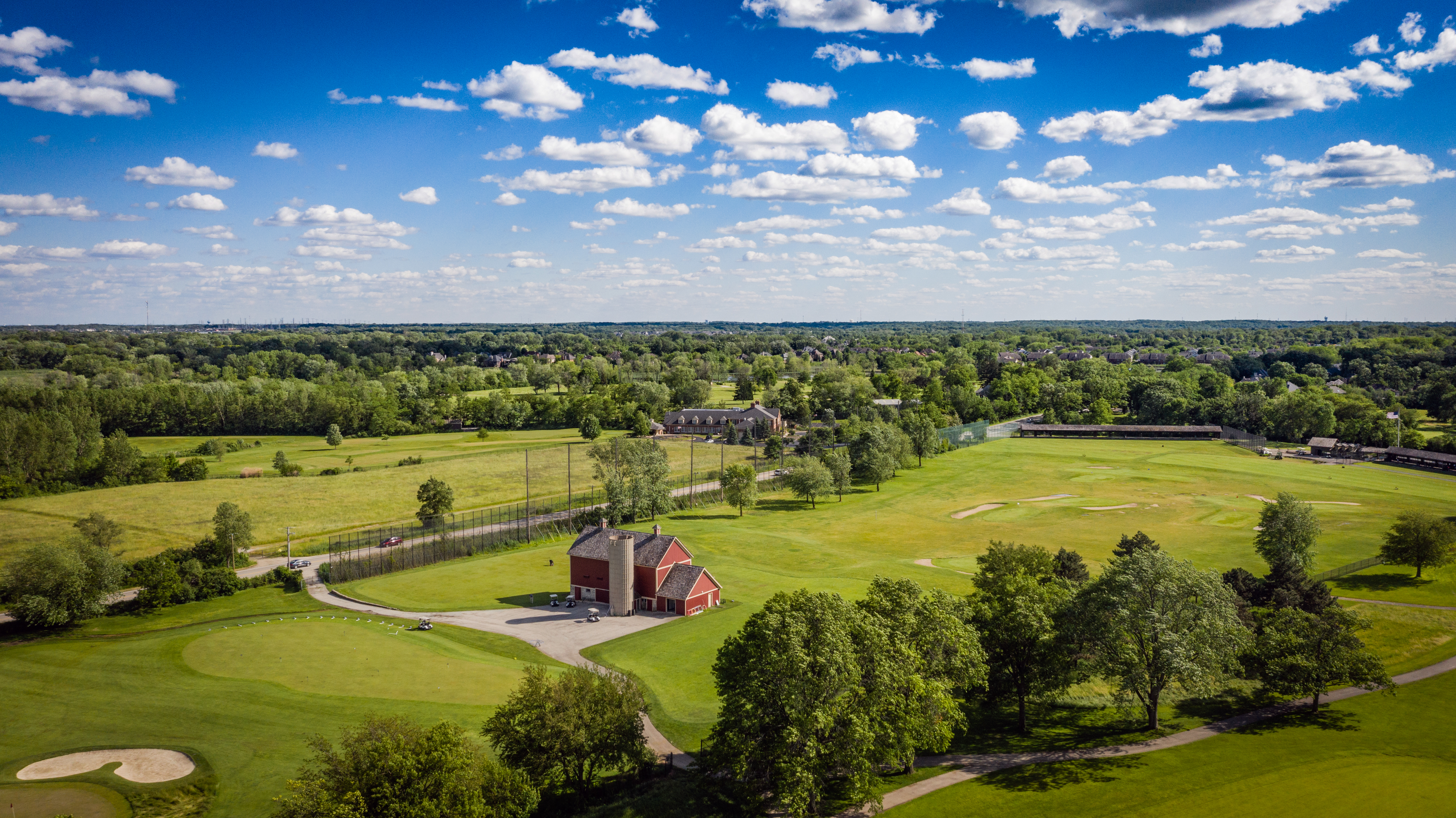 golf course with a red barn